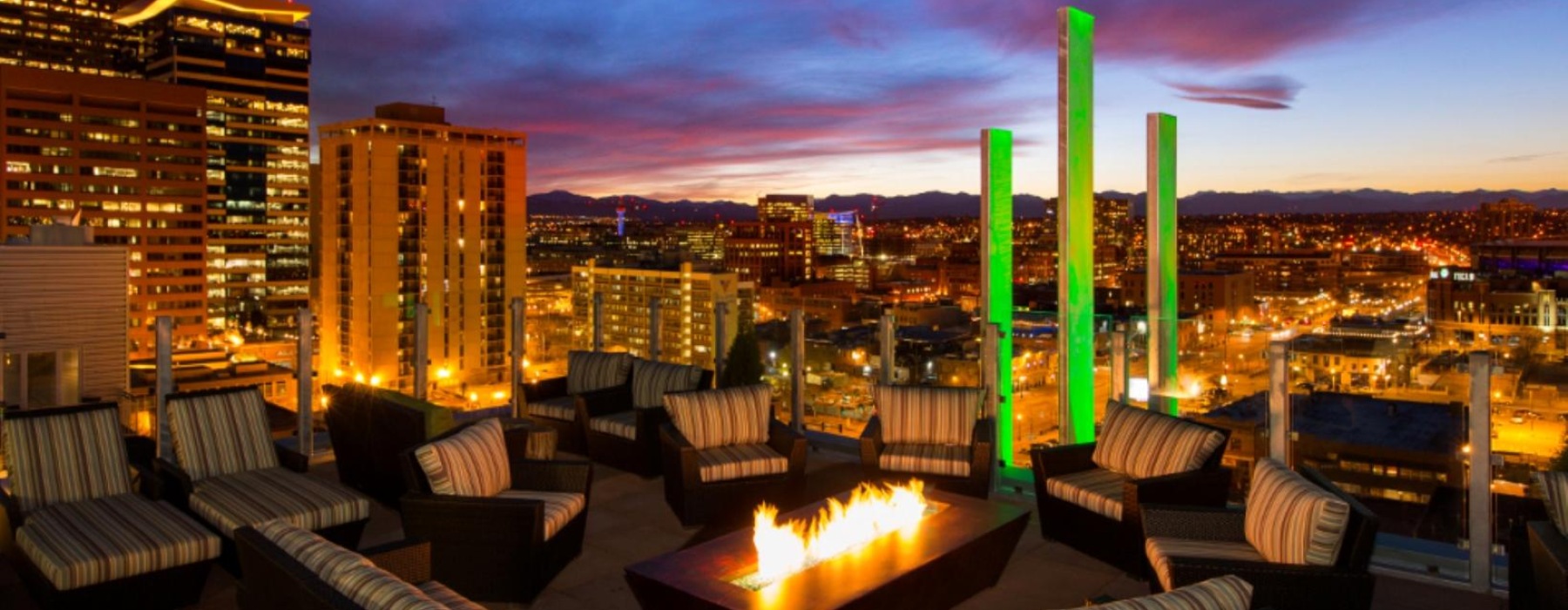 a group of lounge chairs around a fire in a city