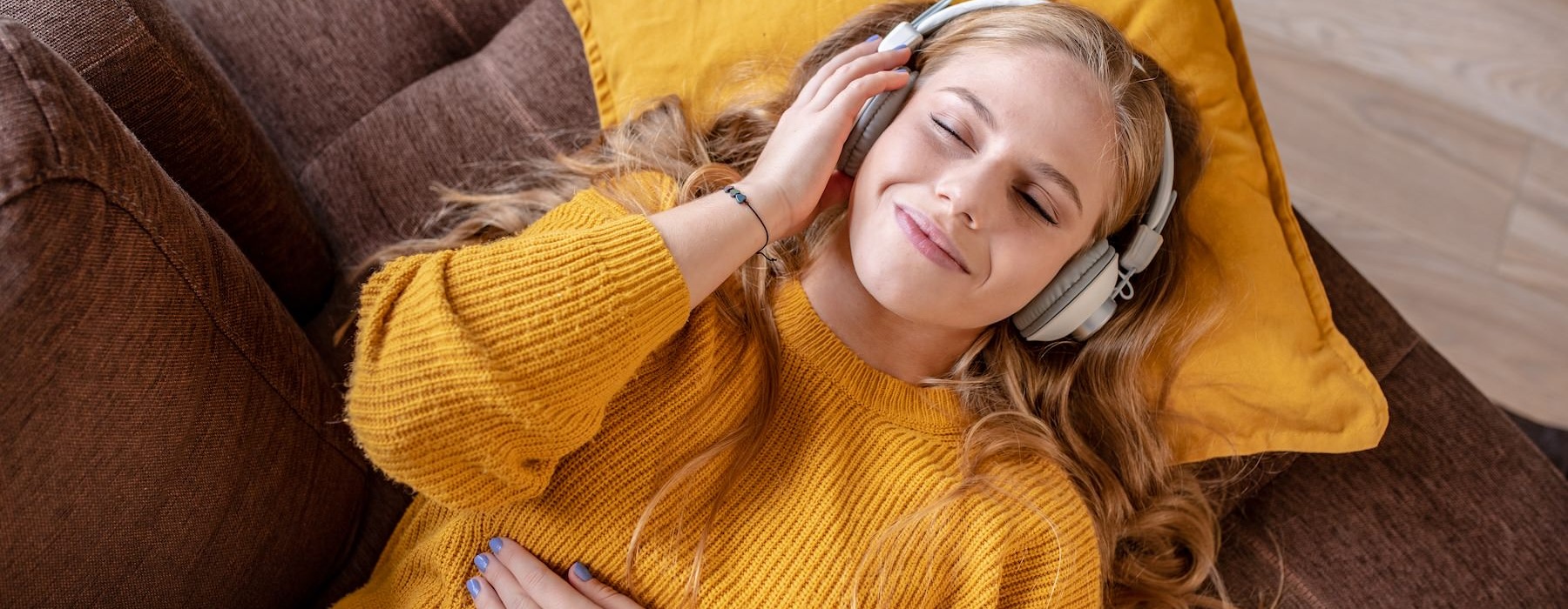a person laying on a couch listening to music
