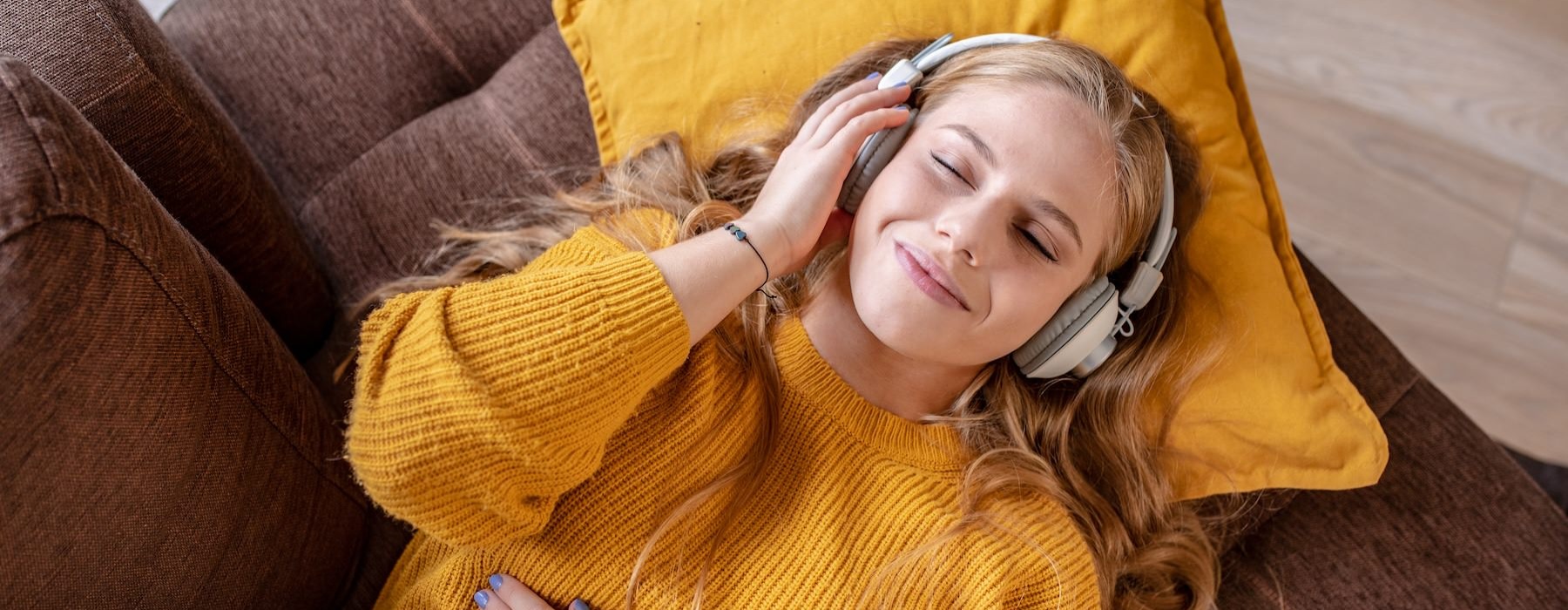 a person laying on a couch listening to music