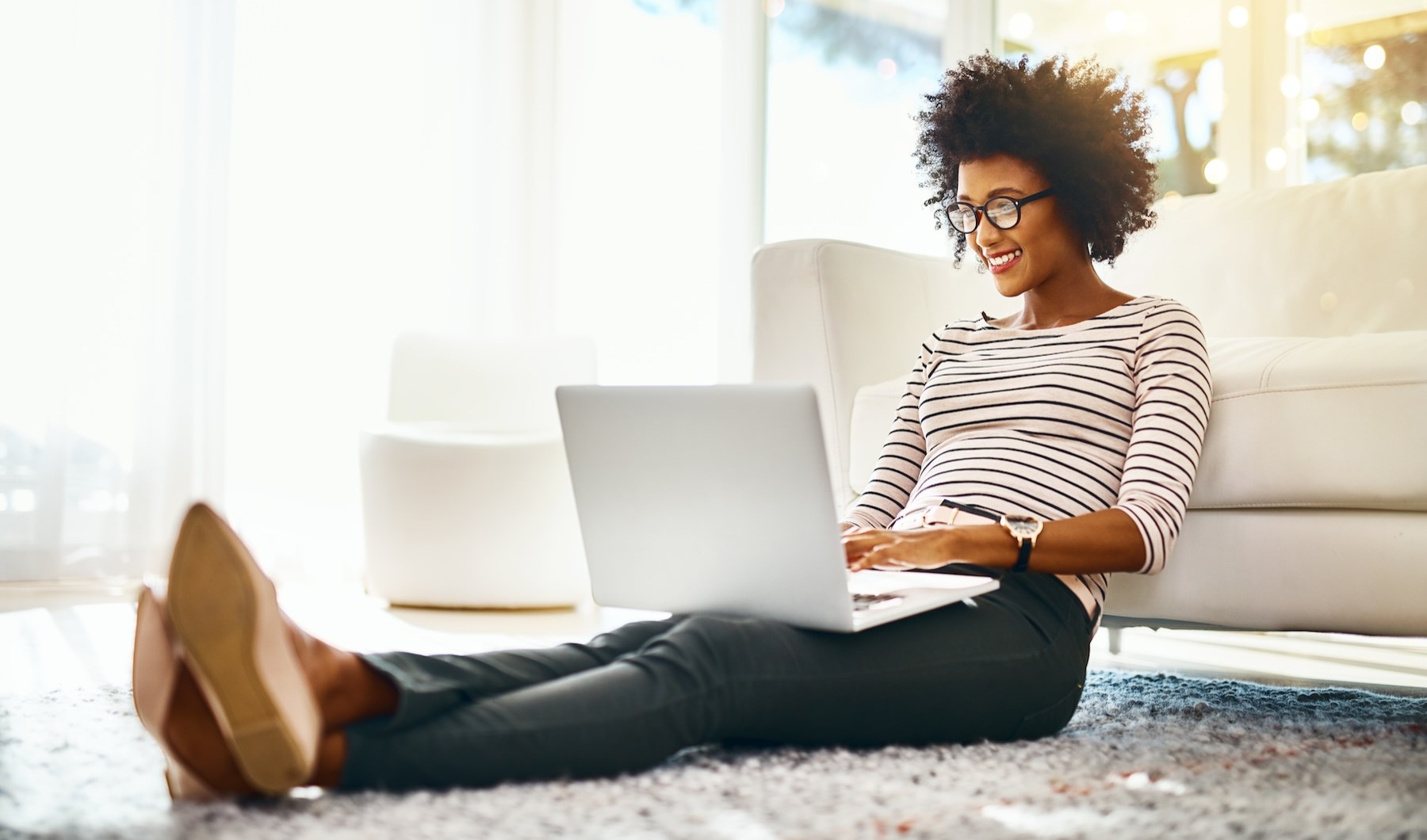 Spacious and well-lit living spaces a person working on a laptop sitting on the ground