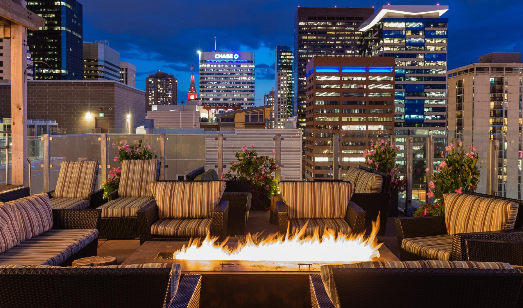 Enjoy our resident-only features a large patio with a fire pit and a city skyline in the background
