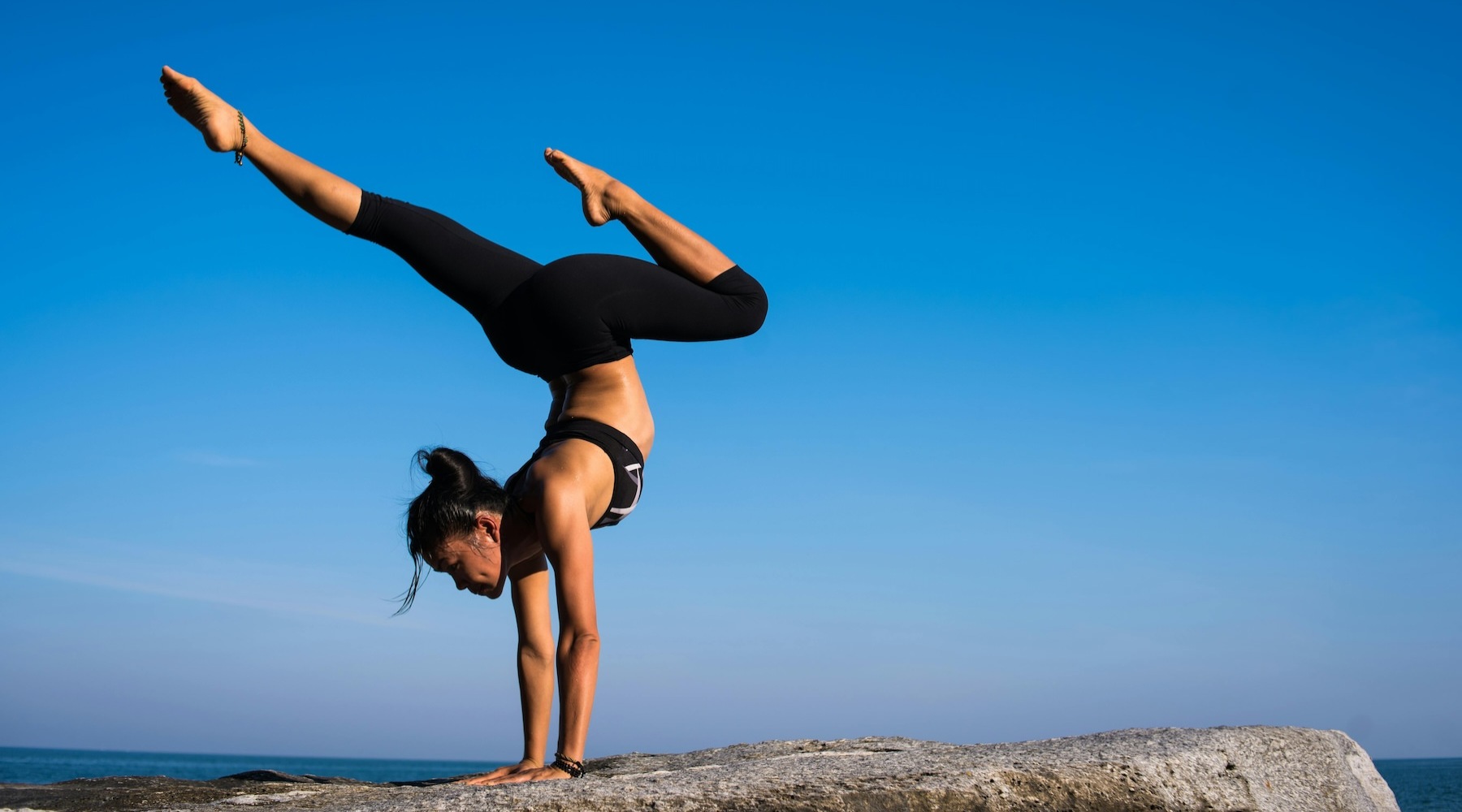A beautiful community at the heart of all your passions a person doing a handstand on a cliff